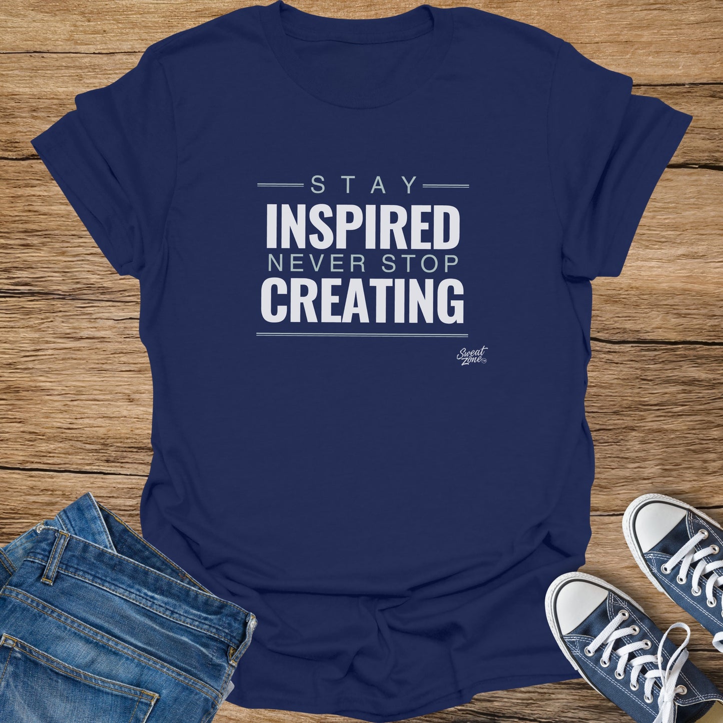 Navy t-shirt with text "STAY INSPIRED NEVER STOP CREATING" and Sweat Zone logo.