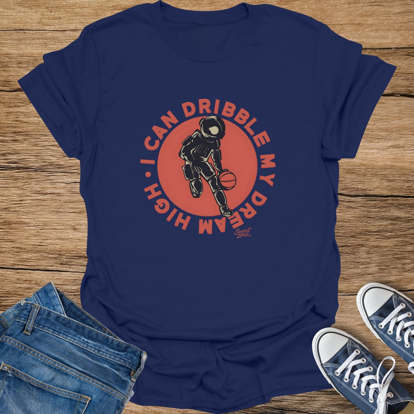 Navy t-shirt with graphic of astronaut dribbling a basketball and text "I CAN DRIBBLE MY DREAM HIGH".