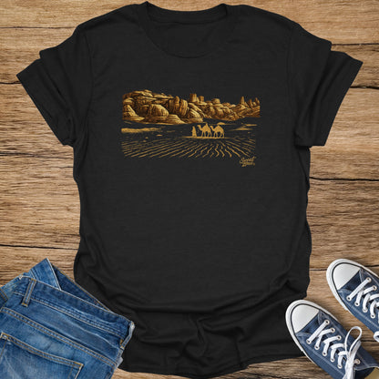 Black t-shirt with desert landscape, camels, figures, and "Sweat Zone" text.