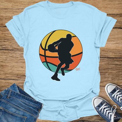 Light blue t-shirt with black basketball player silhouette against a colorful circle and "Sweat Zone" logo.
