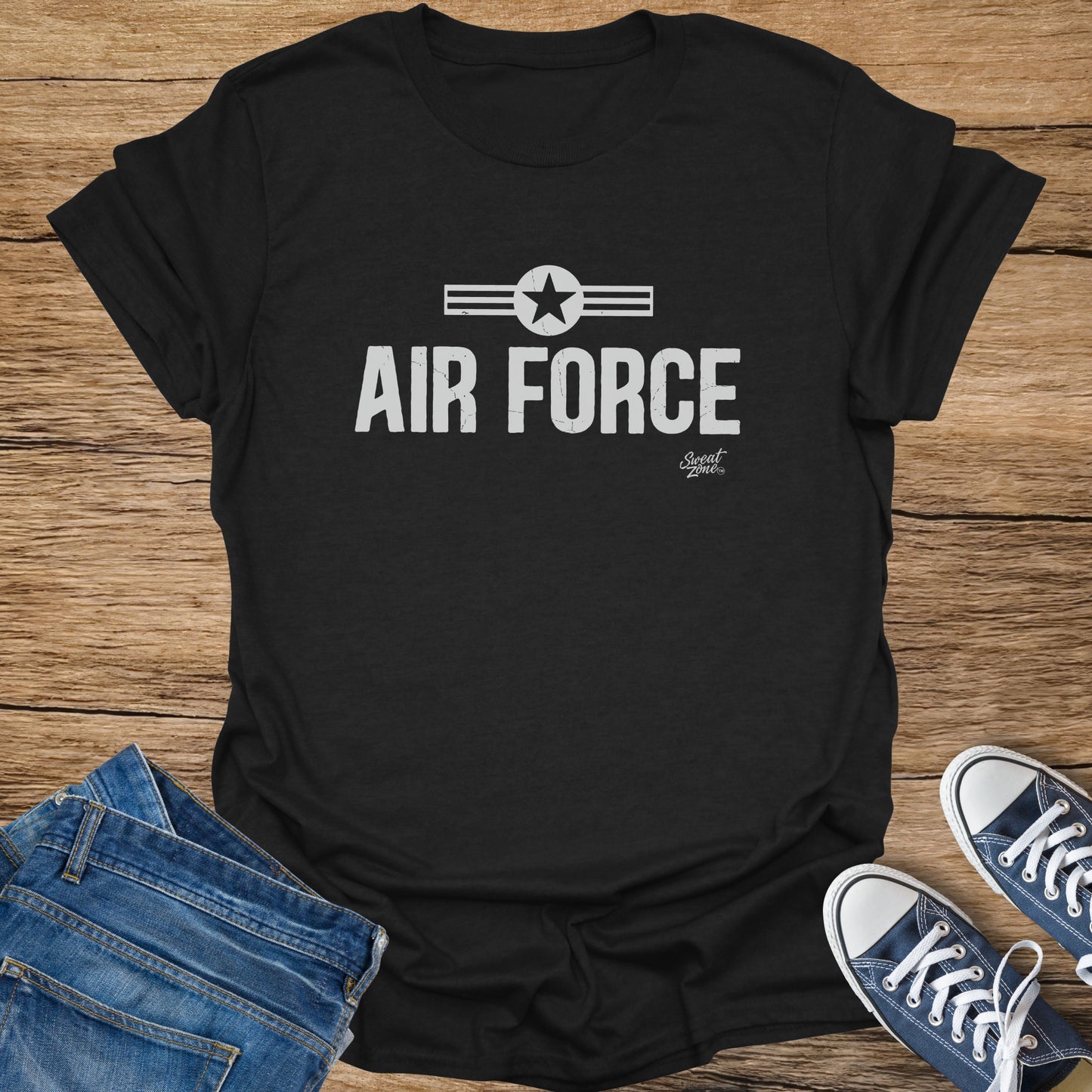 Black t-shirt with "AIR FORCE" text and star emblem, placed with jeans and sneakers.