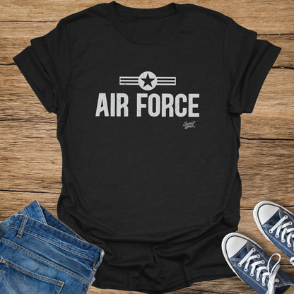 Black t-shirt with "AIR FORCE" text and star emblem, placed with jeans and sneakers.
