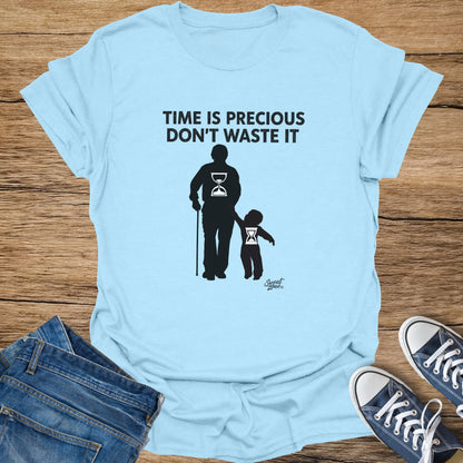 Light blue t-shirt with black text and graphic of figures and hourglasses.