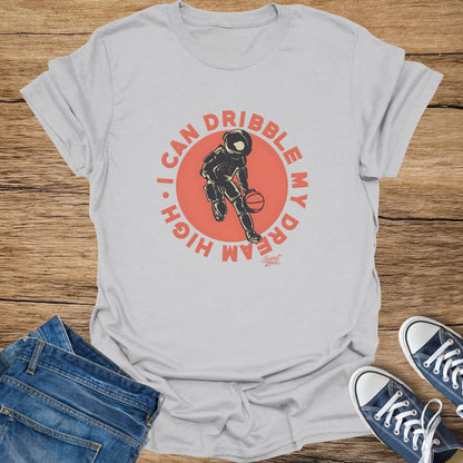 T-shirt with astronaut dribbling a basketball and text "I CAN DRIBBLE MY DREAM HIGH".