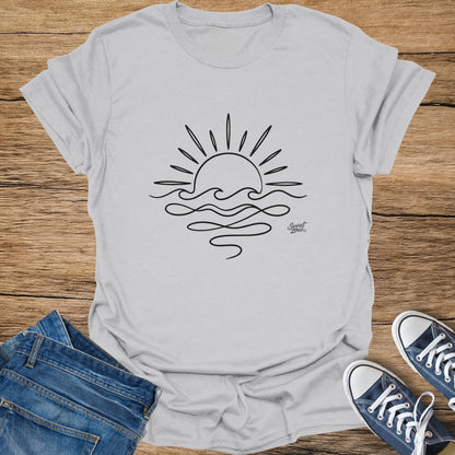 Grey t-shirt with a black line drawing of a sun rising over wavy water.