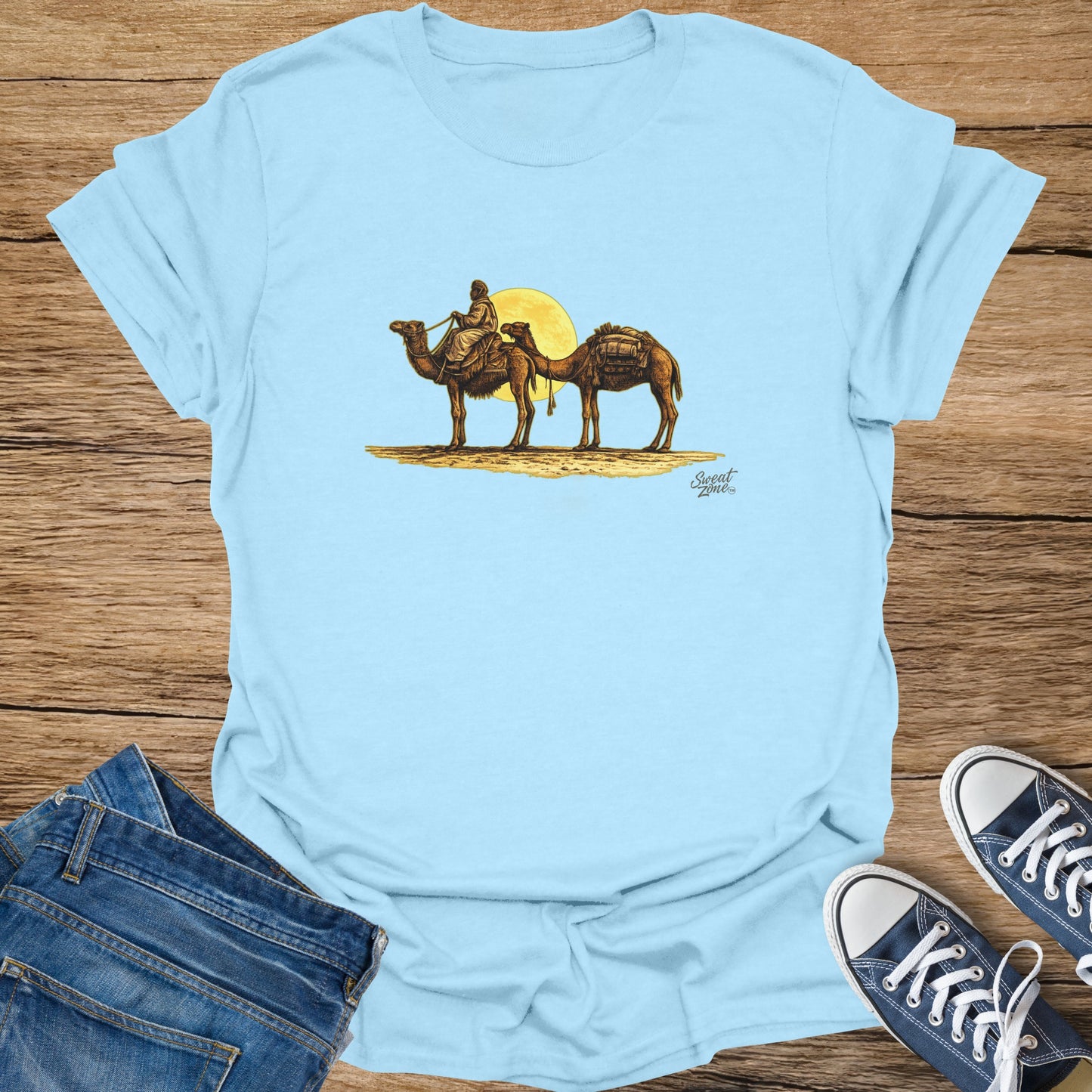 Light blue t-shirt with a desert camel caravan and sun graphic, plus "Sweat Zone" logo.