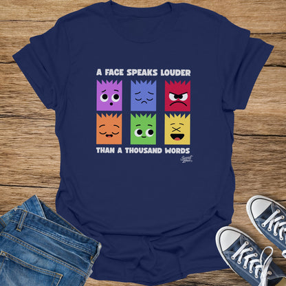 Navy t-shirt with six colorful faces and text "A FACE SPEAKS LOUDER THAN A THOUSAND WORDS."