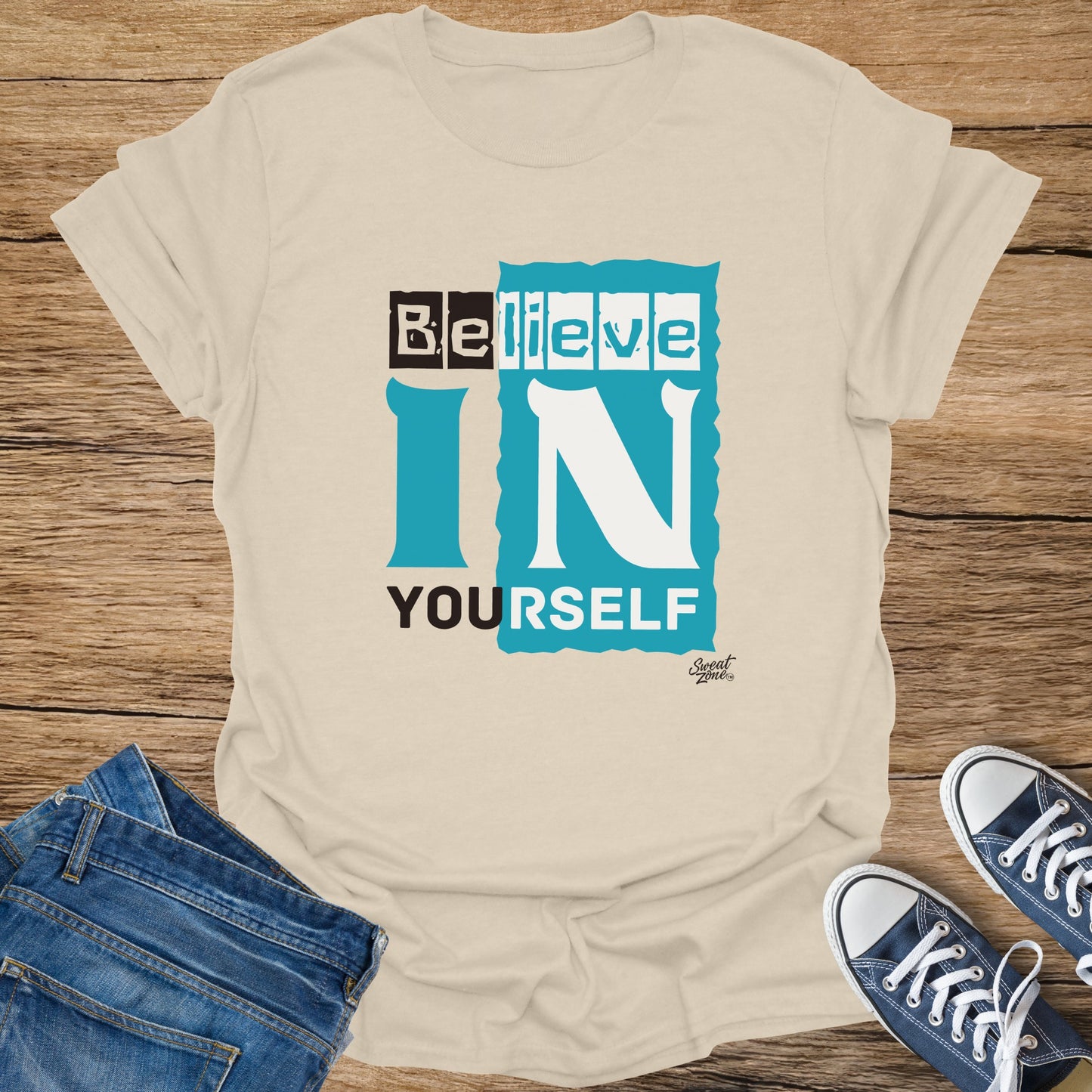 Cream t-shirt with "Believe in Yourself" graphic and a small "Sweat Zone" logo.