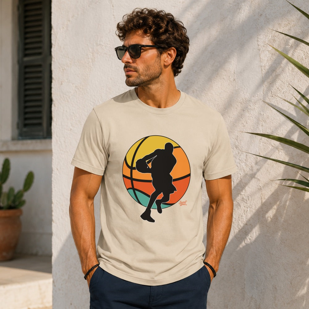 Men's tan t-shirt with a black silhouette of a basketball player mid-dribble on colorful sunset background.