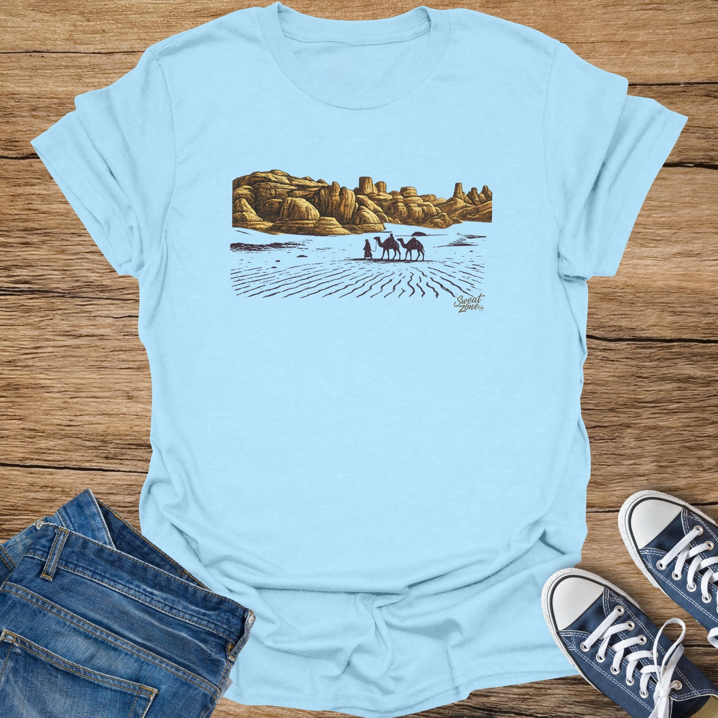 Light blue t-shirt with desert landscape, two camels, and text "Sweat Zone".
