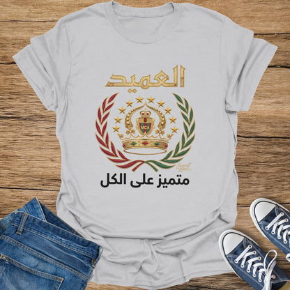 White t-shirt with Arabic text and emblem featuring crown, stars, and laurel wreath.