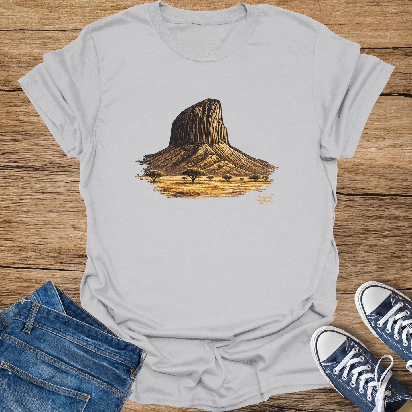 Light grey t-shirt with a graphic of a large rock formation in a savanna landscape.