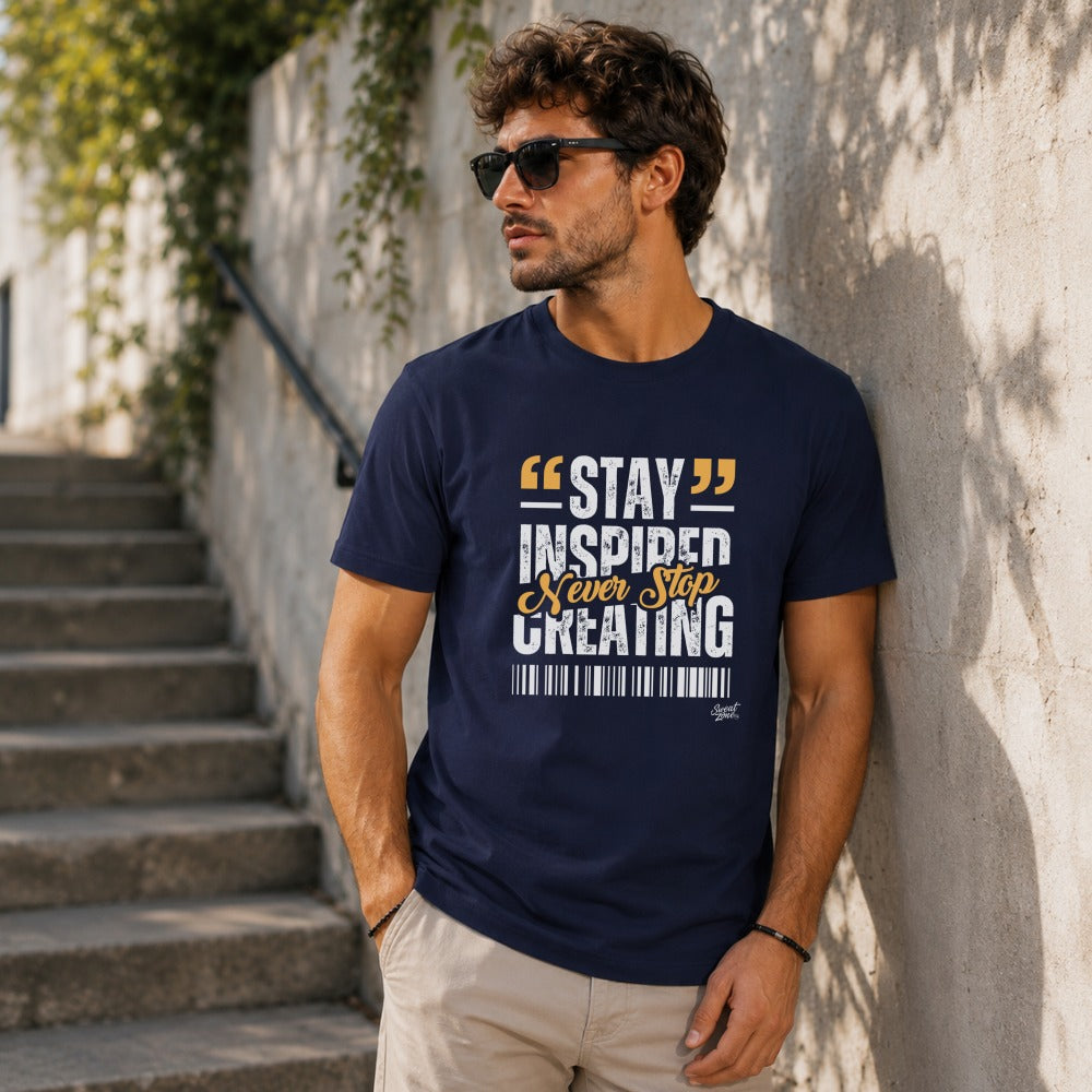 Men's navy t-shirt with "STAY INSPIRED NEVER STOP CREATING" graphic text.
