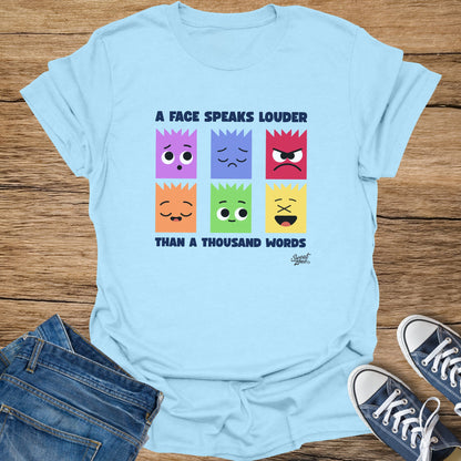 Light blue t-shirt with "A face speaks louder than a thousand words" and six emoji faces.