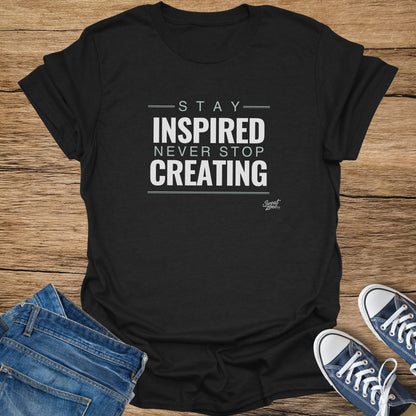 Black t-shirt with "Stay Inspired Never Stop Creating" text and "Sweat Zone" logo.