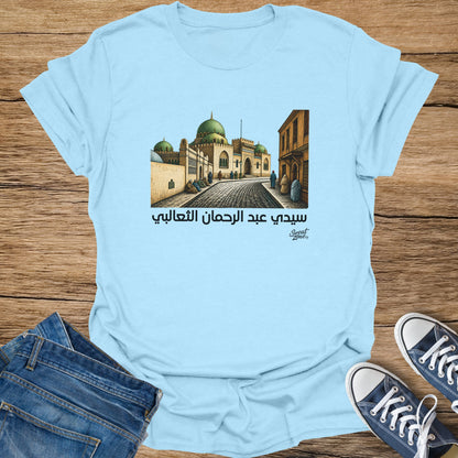 Light blue t-shirt featuring Arabic text and illustration of a mosque with domes.