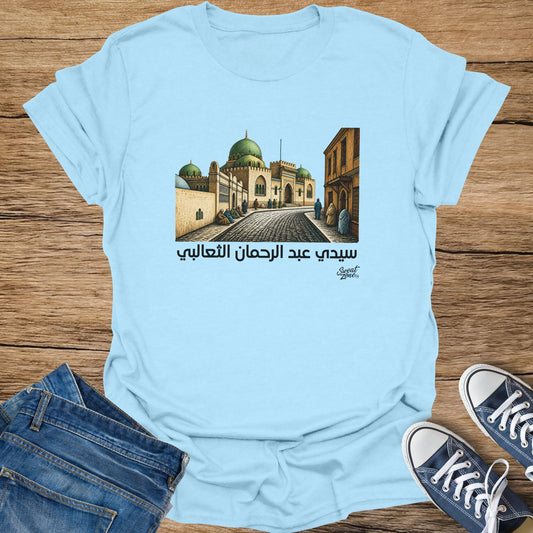 Light blue t-shirt featuring Arabic text and illustration of a mosque with domes.