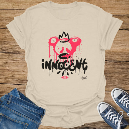 Cream t-shirt with pink and black "INNOCENT" graffiti graphic and crown.