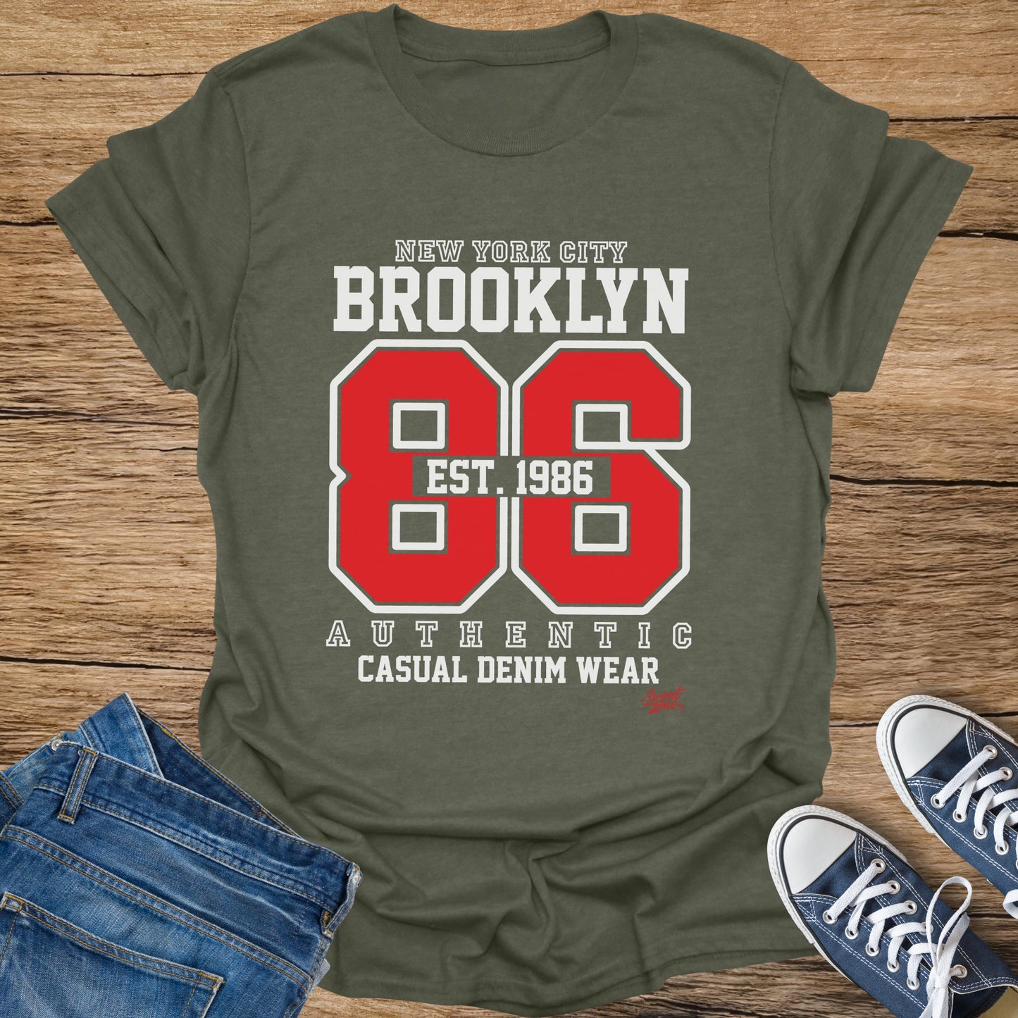 Olive green t-shirt with "Brooklyn Est. 1986" graphic and "Authentic Casual Denim Wear" text.