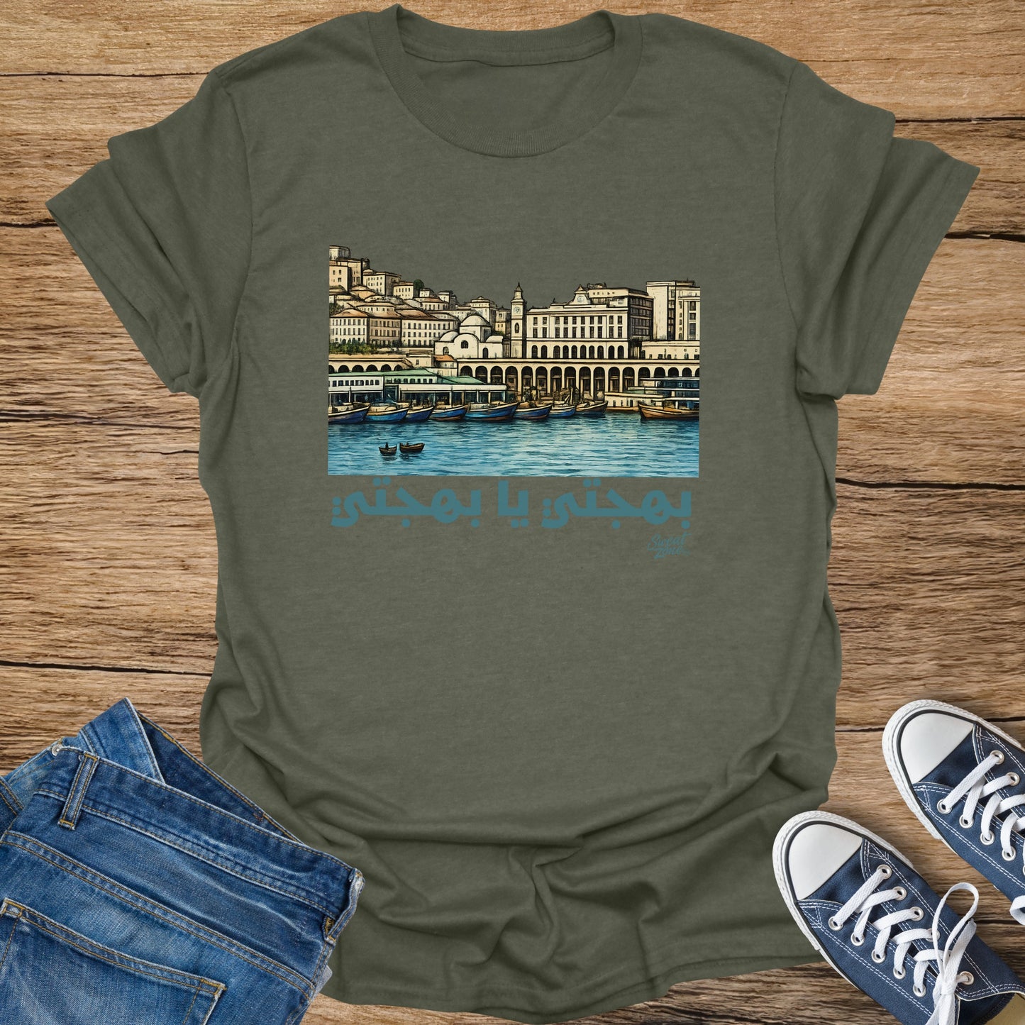Green t-shirt with Arabic script and harbor illustration.