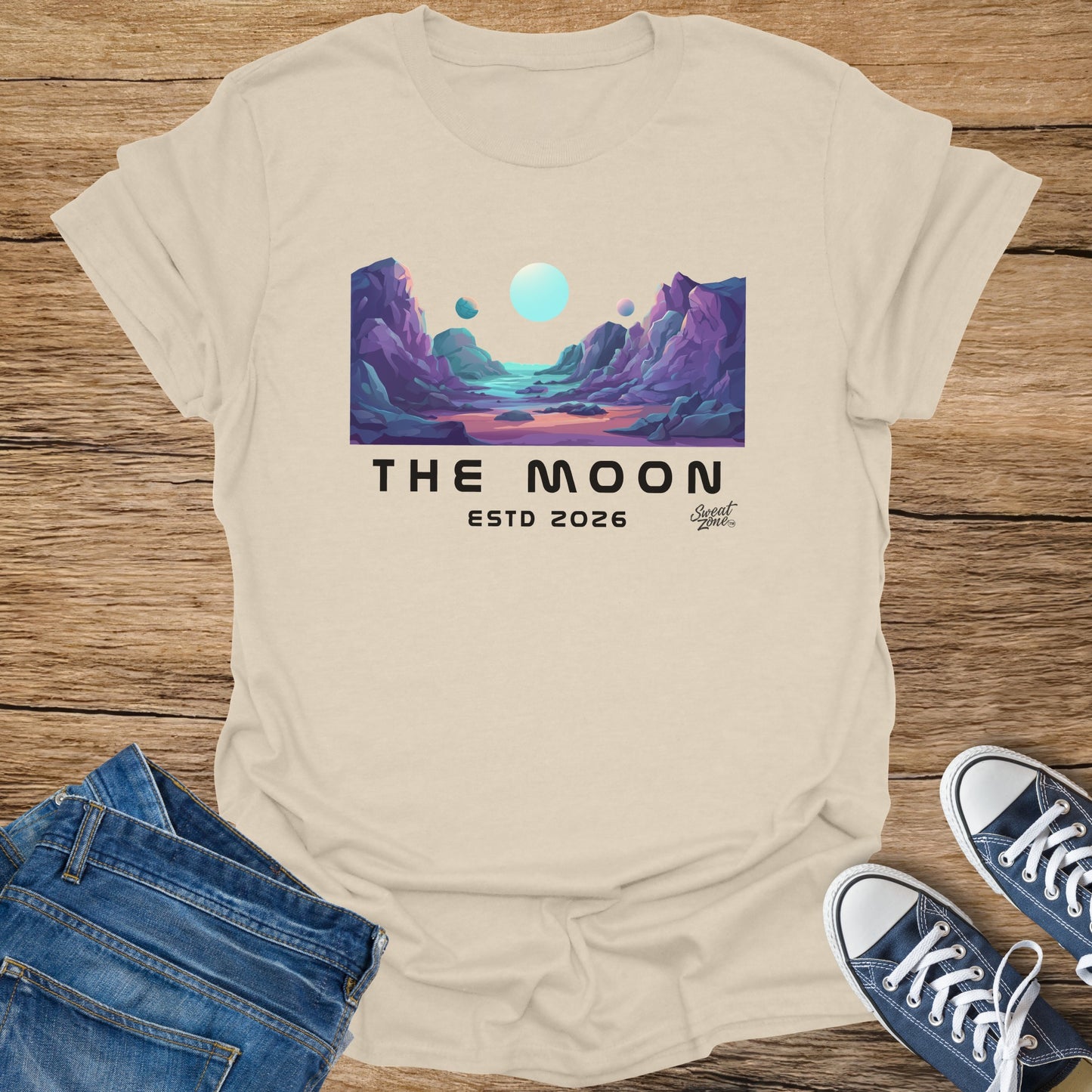 Beige t-shirt with "THE MOON ESTD 2026" text and lunar landscape graphic.