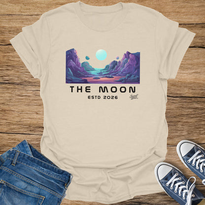 Beige t-shirt with "THE MOON ESTD 2026" text and lunar landscape graphic.