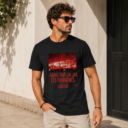 Black t-shirt with red graphic depicting city lights and text in Arabic and French titled "LÊS FUMIGÈNES".