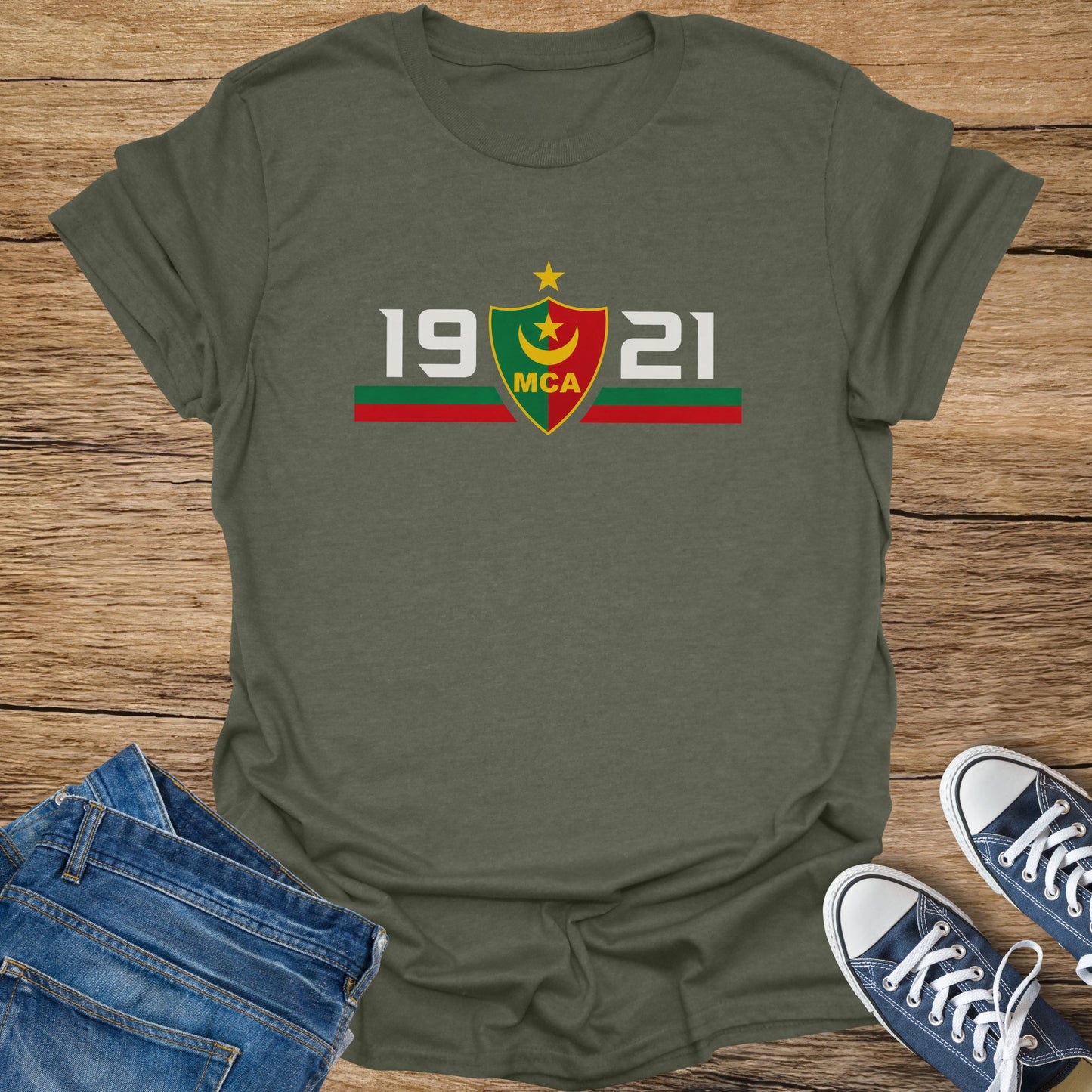 Khaki t-shirt with white text "1921 MCA" and a shield emblem.