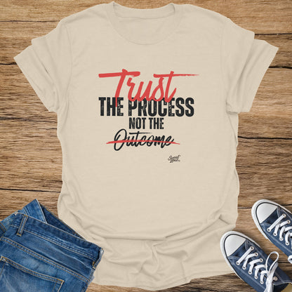 Cream t-shirt with "Trust the Process Not the Outcome" distressed text in black and red.
