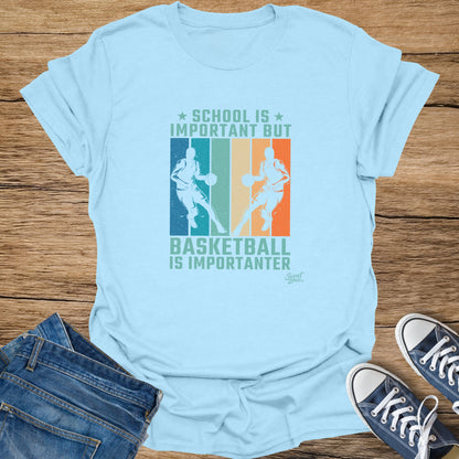 Light blue t-shirt with "School is Important But Basketball Is Importanter" text and basketball player graphics.