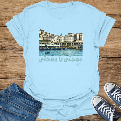 Light blue t-shirt with an Arabic phrase and a harbor scene illustration.