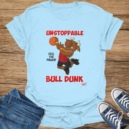 Light blue t-shirt with a cartoon bull dunking a basketball, text "UNSTOPPABLE" and "BULL DUNK".