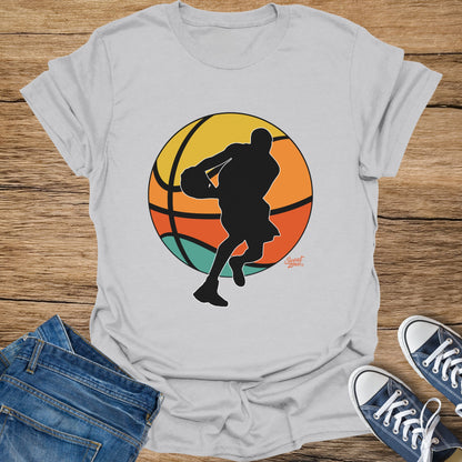 T-shirt with a black silhouette of a basketball player against a circular sunset.