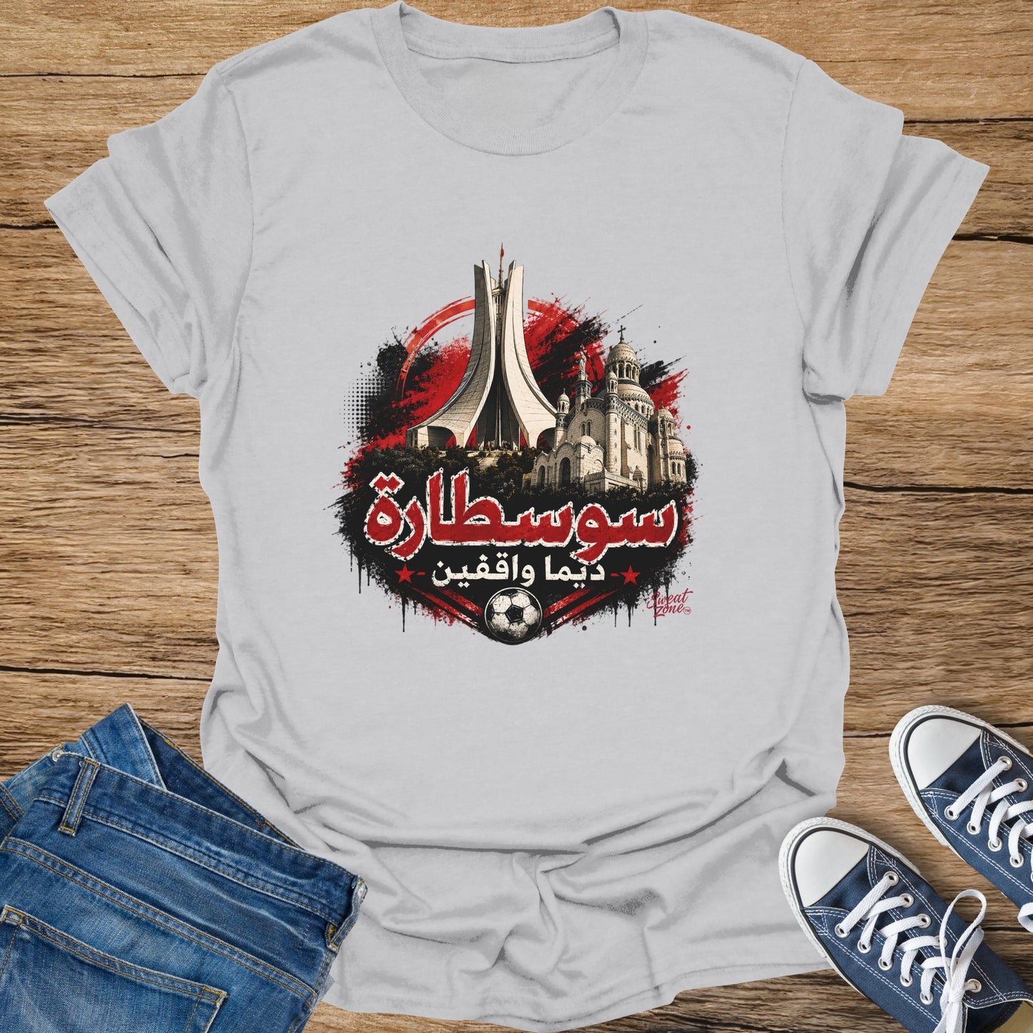 White t-shirt with Arabic text, architectural landmarks, and a soccer ball graphic.