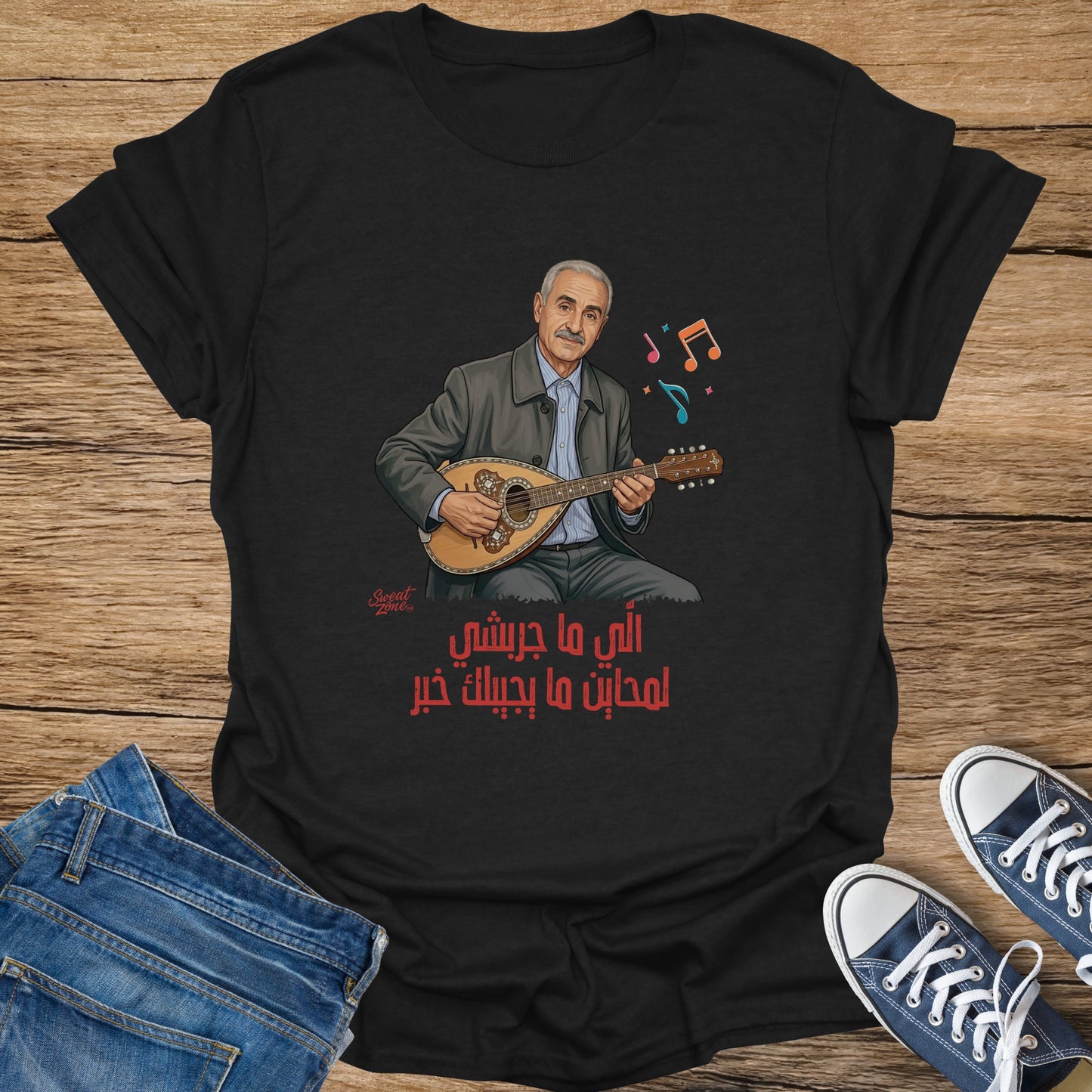 Black t-shirt featuring a cartoon man playing a lute with Arabic text and musical notes.