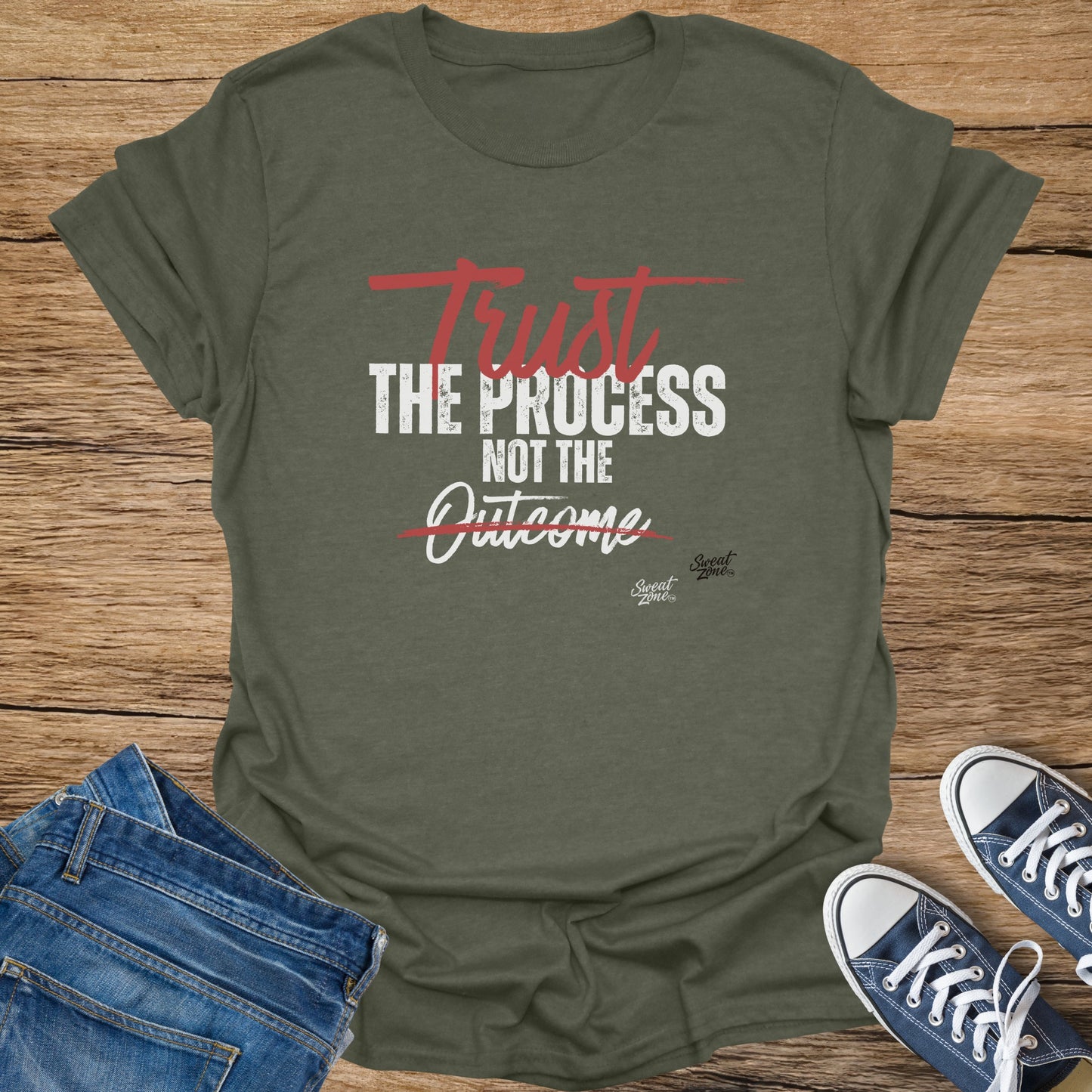 Olive green t-shirt with "Trust The Process Not The Outcome" text and logos.