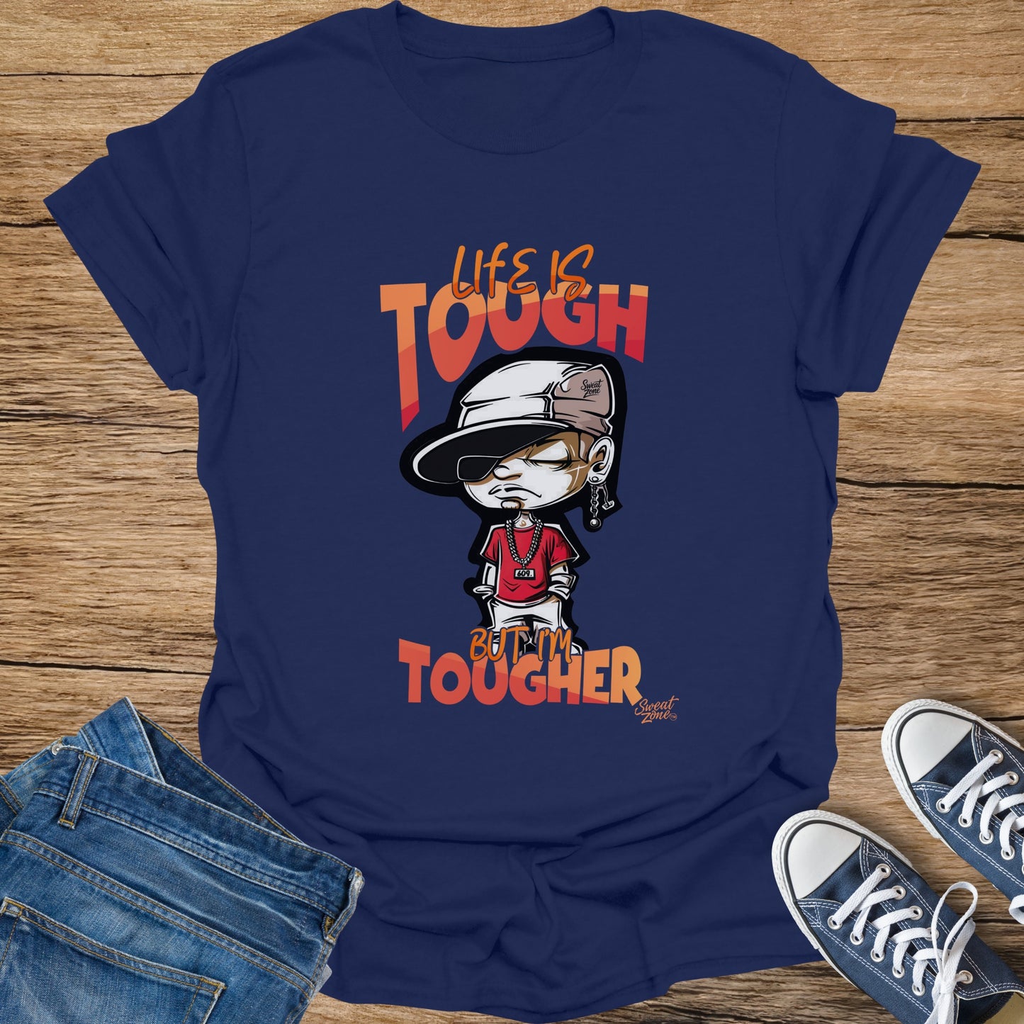 Navy t-shirt with cartoon of a person wearing a hat and gold chain and text "Life is Tough But I'm Tougher".