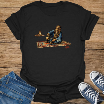 Black t-shirt with desert nomad pouring tea by campfire illustration.