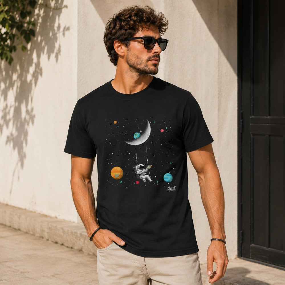 Black t-shirt with astronaut swinging on the moon amidst planets and stars.
