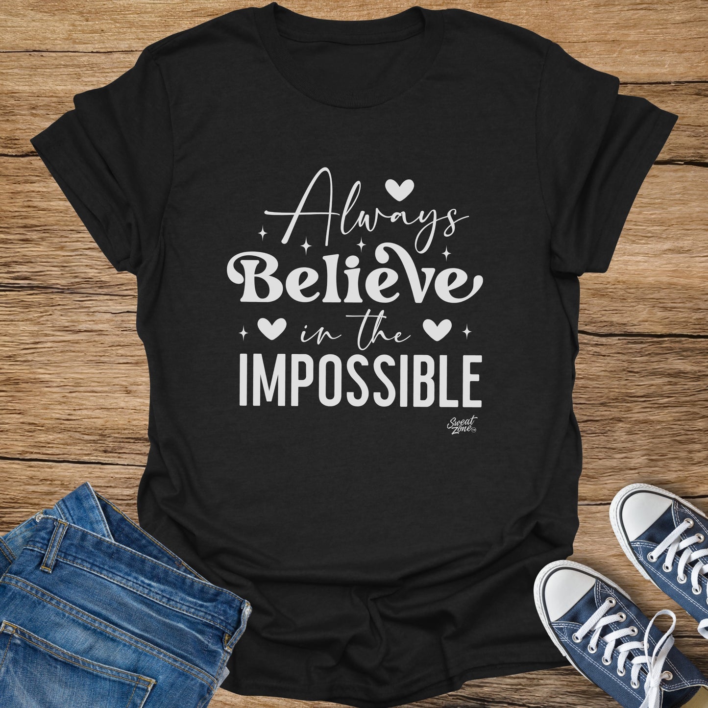 Black t-shirt with white text "Always Believe in the IMPOSSIBLE" and "Sweat Zone" logo.