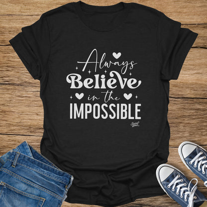 Black t-shirt with white text "Always Believe in the IMPOSSIBLE" and "Sweat Zone" logo.