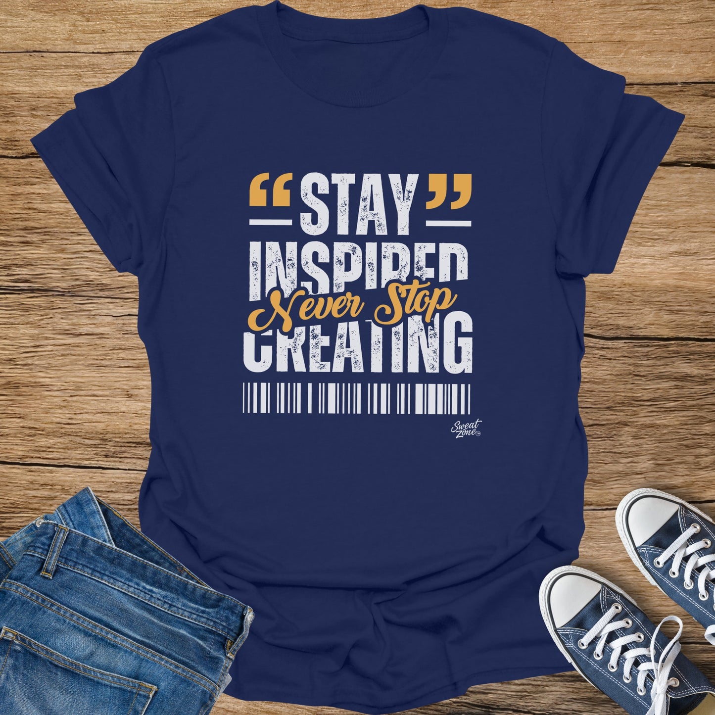 Navy t-shirt with white and orange text "STAY INSPIRED Never Stop CREATING".