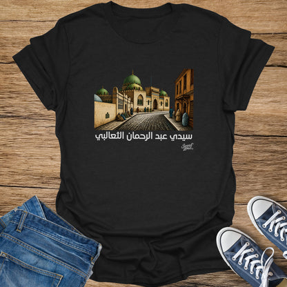 Black t-shirt with Arabic text and illustration of a mosque and street.