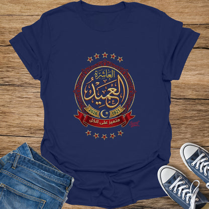 Navy t-shirt with gold Arabic calligraphy, "2026 1921", and red ribbon design.