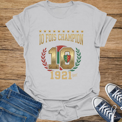White t-shirt with gold text "10 FOIS CHAMPION", a large "10", and "1921".