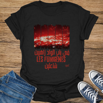 Black t-shirt with red Arabic text and white "LES FUMIGENES".