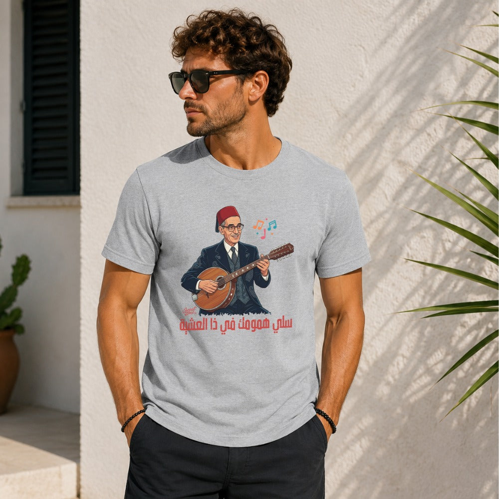 Grey t-shirt with graphic of man playing oud with Arabic text "سلي همومك في ذا العشية".