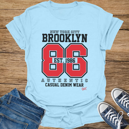 Light blue t-shirt with Brooklyn 86 Est. 1986 Authentic Casual Denim Wear text.