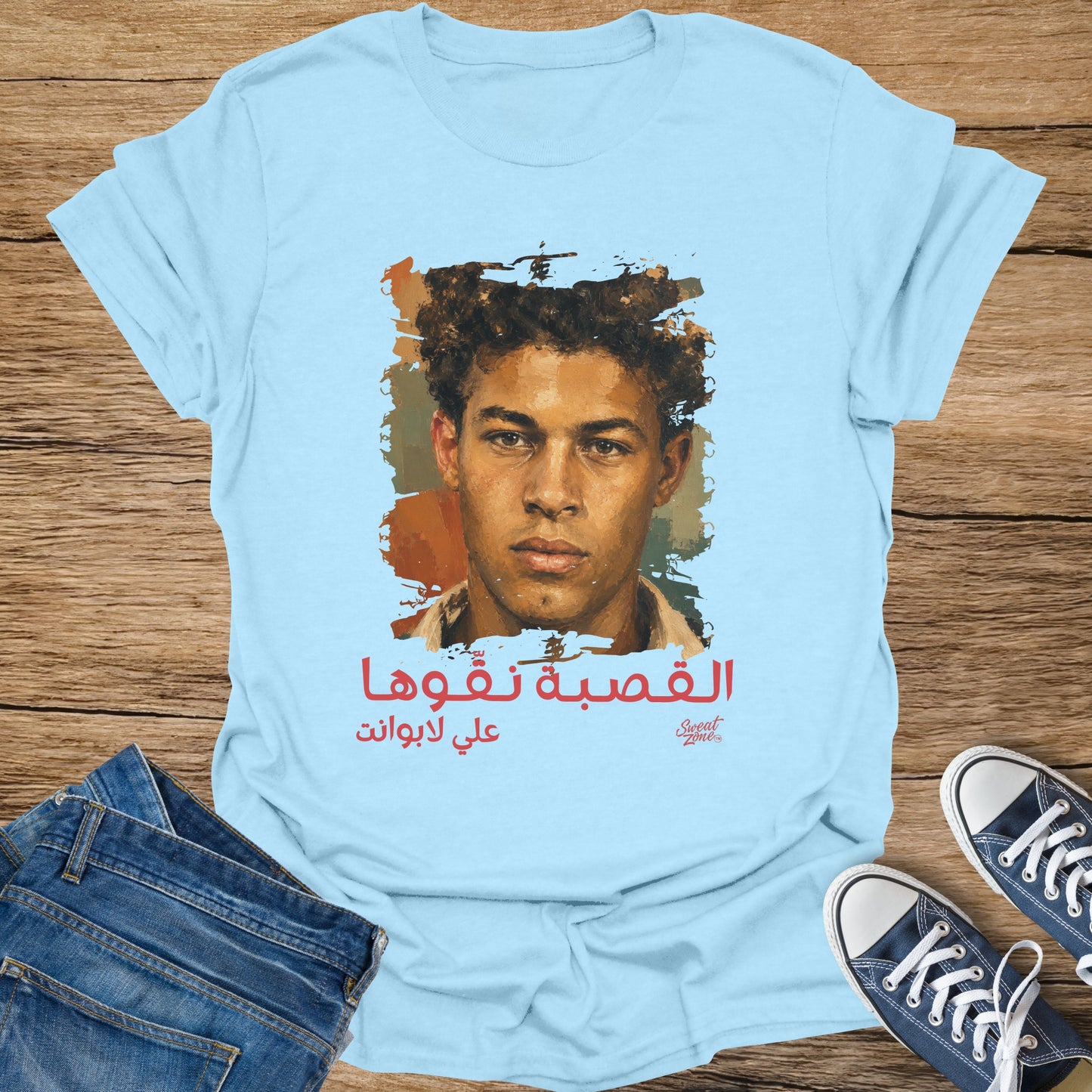 Light blue t-shirt with a portrait and Arabic text about sweat.