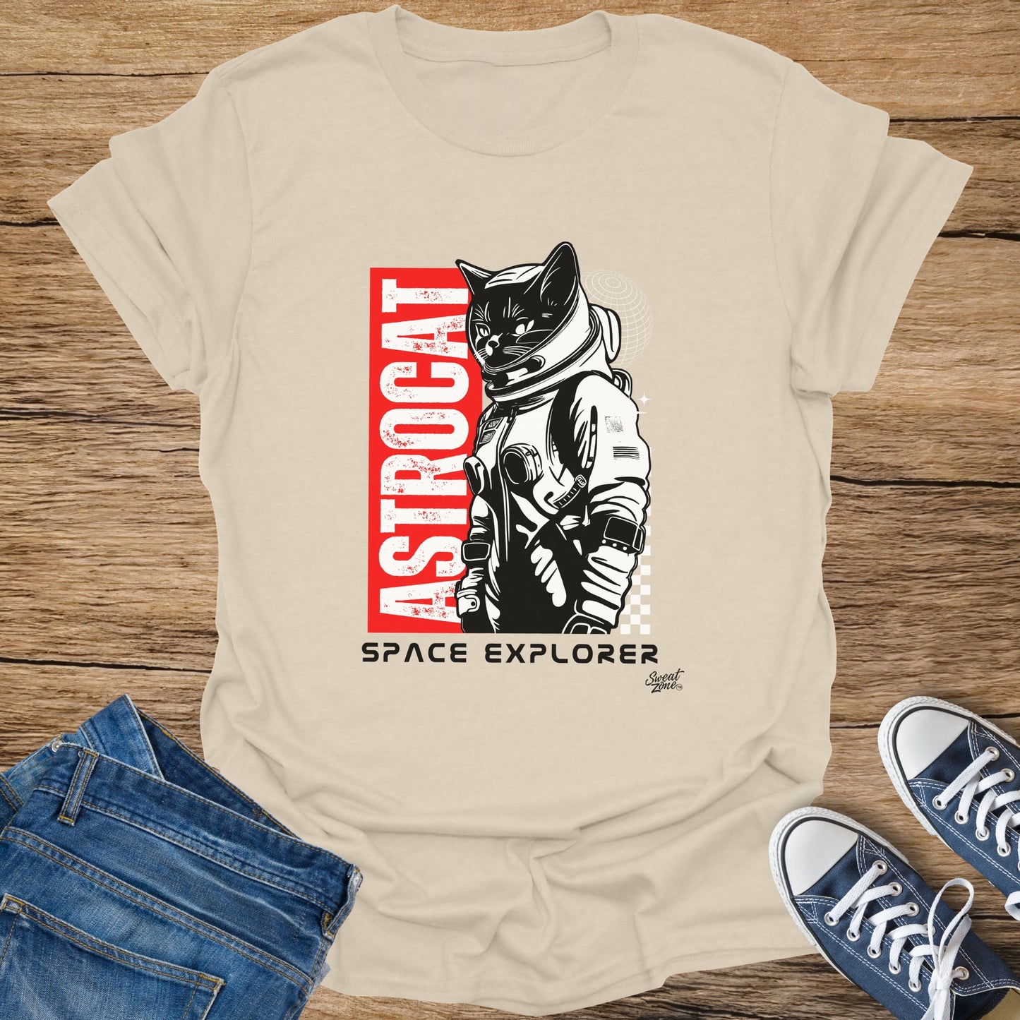 Astronaut cat graphic with text "ASTROCAT" and "SPACE EXPLORER" on a cream t-shirt.